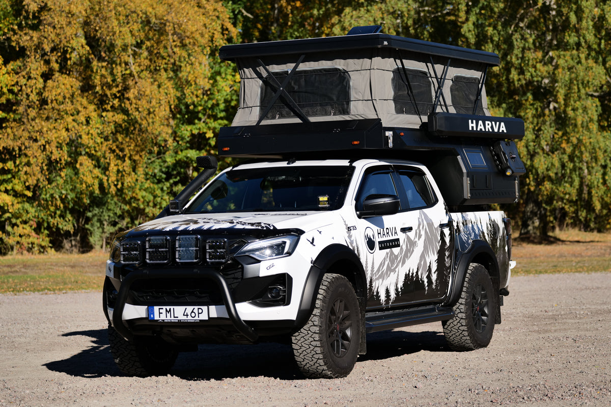 Fjärden pickup-camper med uppfällt tak, sedd snett framifrån
